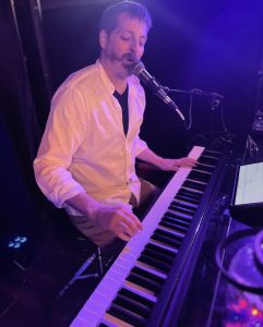 Greg Percifield playing a piano at Crescent City Tap