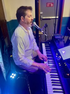 a man sitting on a chair playing a piano